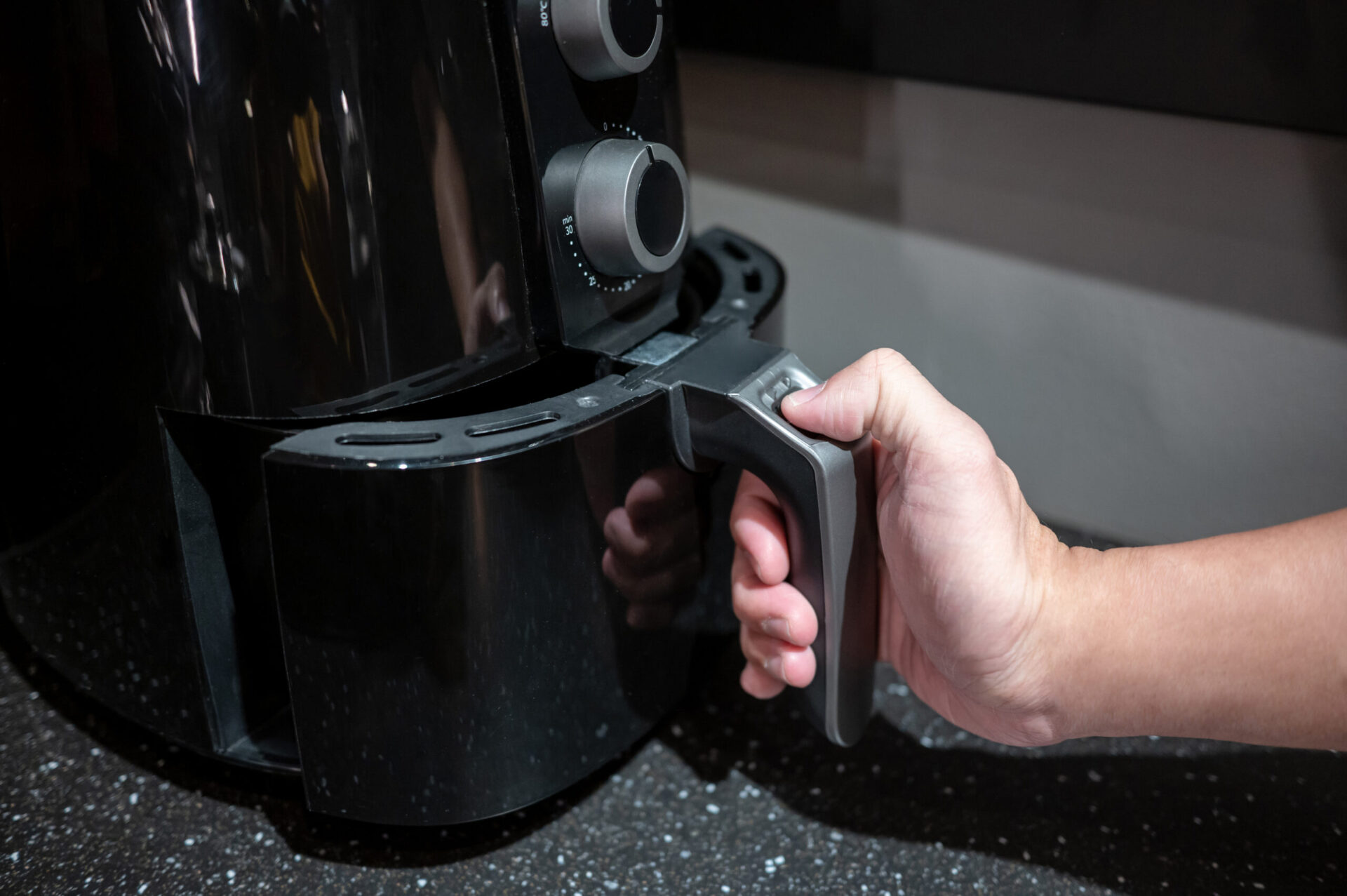 Male hand holding an electric air fryer